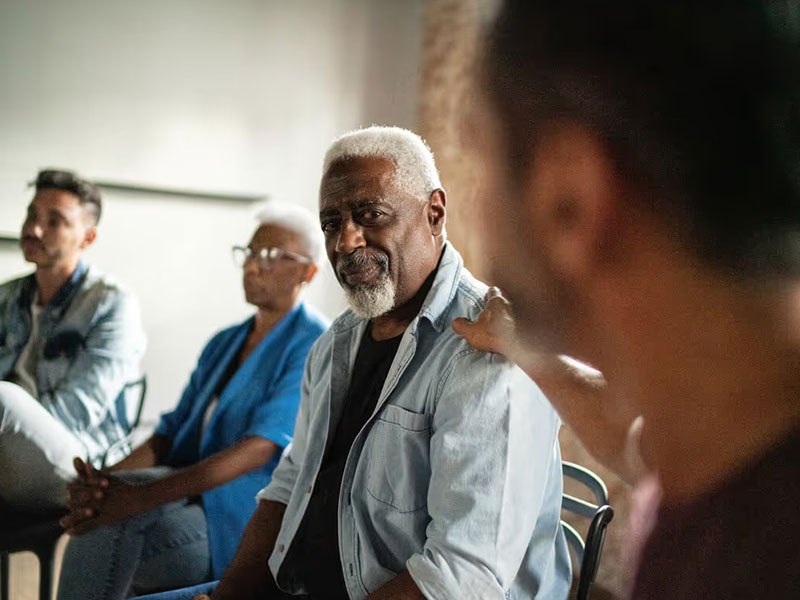 Man comforting another man holding his shoulder