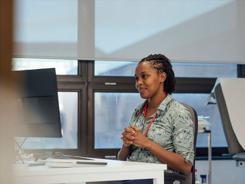 Lady in green flower pattern shirt clasping hands