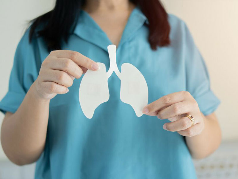 Nurse holding up paper cut out lungs