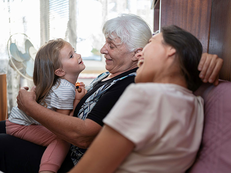 Three generations hugging on sofa