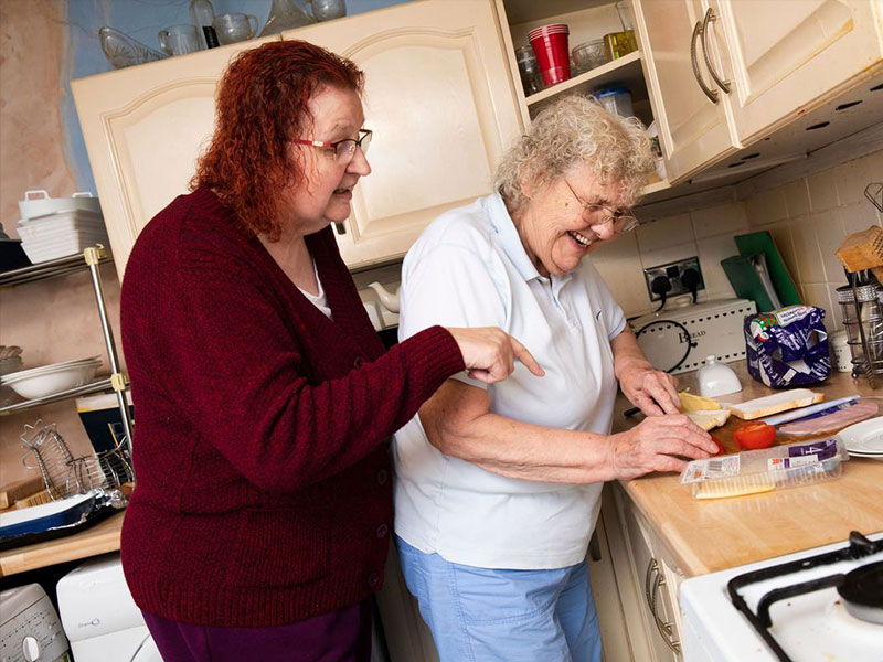 Woman in red cardigan advising in kitchen