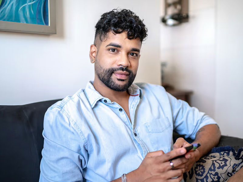 Young Asian man in blue shirt on phone